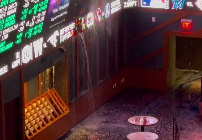 Floodwater pours through the walls of a casino.